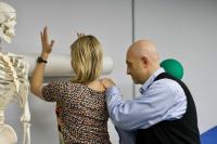 a physical therapist helping a person stretch her arm